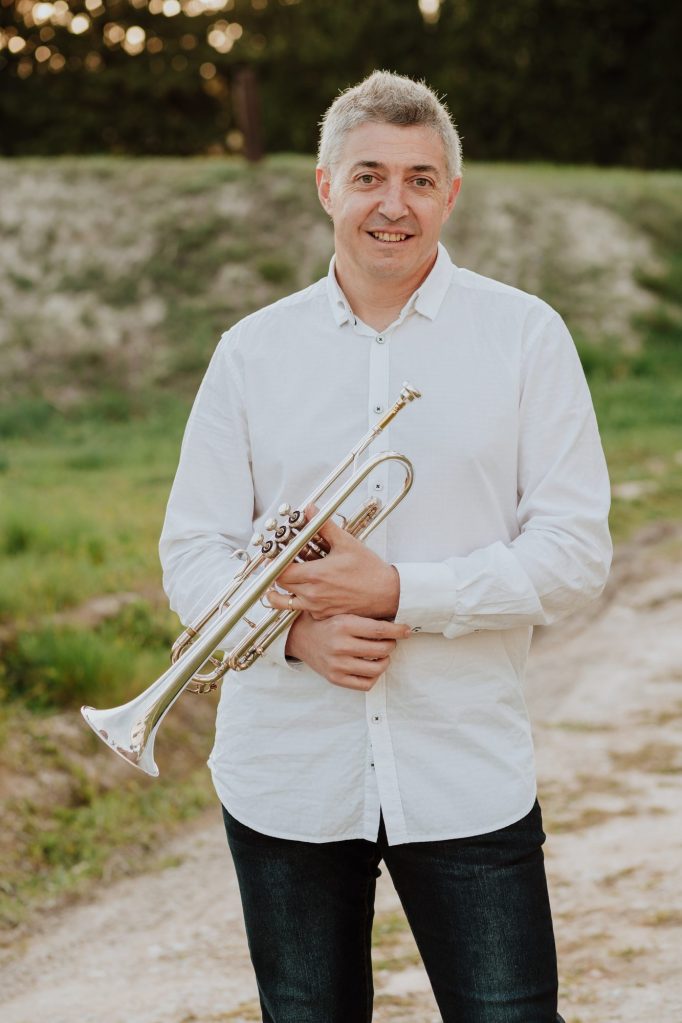 José Cháfer sonriendo con su trompeta al aire libre